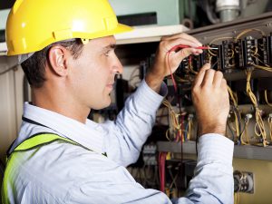 male professional electrician testing industrial machine